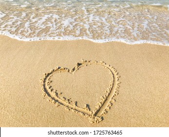 A drawing of a heart on wet beach sand at a beautiful seascape background. Texture. - Powered by Shutterstock