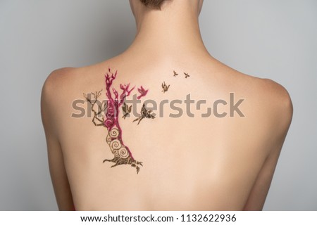 Drawing henna on the back. Oriental picture on woman shoulder blade, horizontal banner. mehendi traditional decoration, resistant design brown henna mehandi art. Conceptual idea freedom. Concept draw