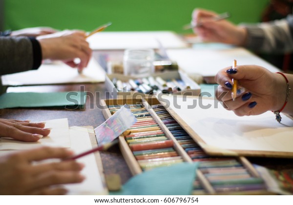 Drawing lesson for children and adults. Pastel\
pencils. Beautiful pastel picture. many people. Box with pencils on\
the table. Many\
materials.