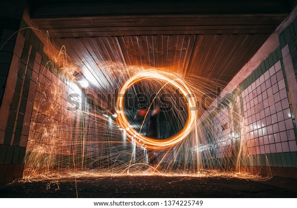 drawing light at night in an\
underground tunnel, splashes of light and sparks,\
freezelight