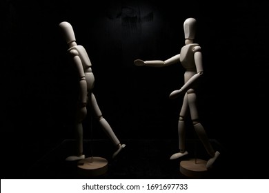 A drawing mannequin walking away from another one who is trying to stop it - Powered by Shutterstock