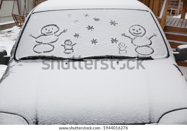 Drawing on the\
glass of a car covered with\
snow.