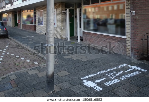 Drawing on pavement in Dutch\
letters means, \'We beat Corona together, this is 1.5 meters, keep\
your distance!\' Coronavirus measures and rules for social\
distancing.