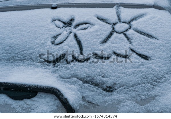 drawing on\
the windshield of the car, winter\
weather.