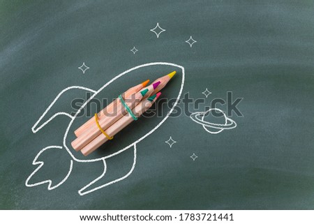 Drawing of a rocket with pencils on blackboard. Back to school concept