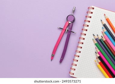 Drawing Tools and Colorful Pencils on Purple Background with Notebook: Back to School Supplies - Powered by Shutterstock