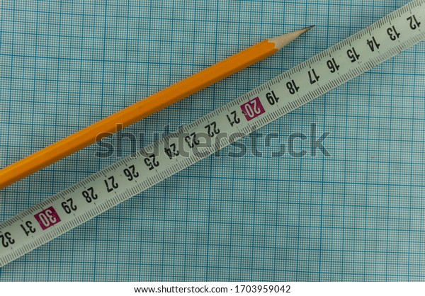 drawing tools: drawing compass; pencil;\
and ruler on graph paper background with copy\
space