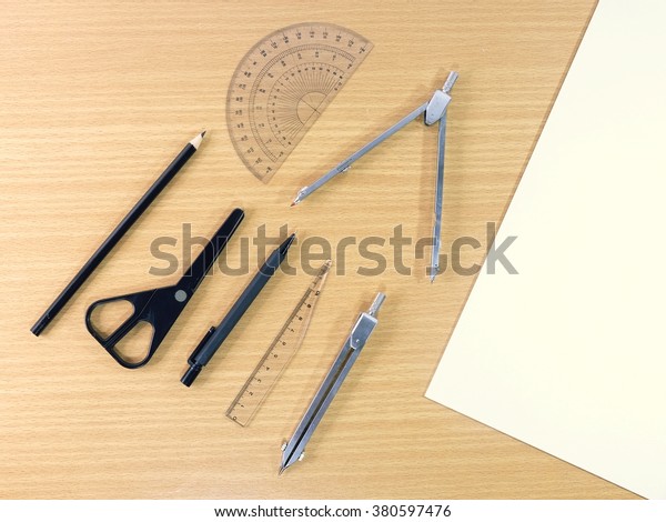 Drawing tools and\
pencils on wooden table