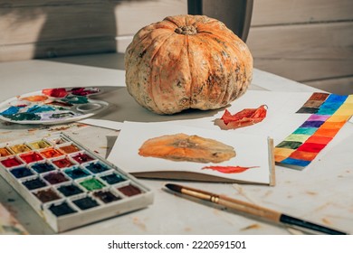 Drawing in watercolor in sketchbook  Autumn still life and pumpkin   red leaf  Learning to draw at home  Creating content concept 