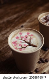 Drawings On Coffee. Male And Female Cappuccino Decoration. Hot Drink In A Paper Cup. Picture Of A Chocolate Mountain And Japanese Cherry Blossom. Food Industry Creativity Concept