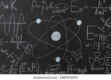 Drawn atomic structure and physics formulas on black chalkboard