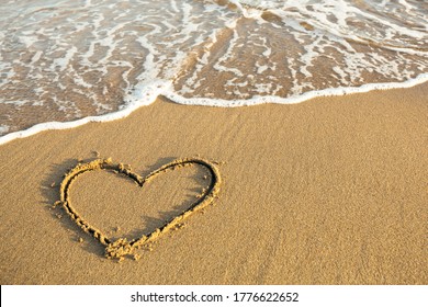 Drawn Heart on the sand of a sea tropical beach.