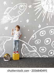 Dream big! Happy child playing outdoor  Funny kid draws chalk rocket the wall  Child dreaming about space  Kid pretend to be astronaut  Children dream   imagination concept 