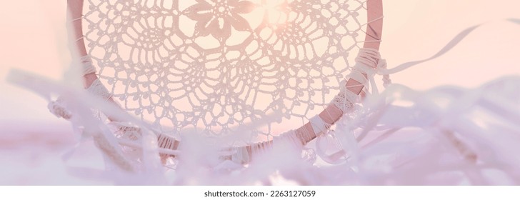 Dream catcher against sunrise.  Harmony with nature. Close-up. Horizontal banner for a website. Bookmark for a book. Poster for the bedroom