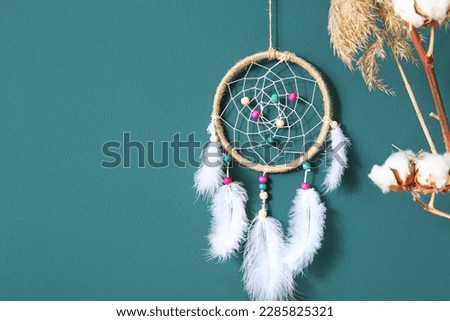 Dream catcher hanging on color wall in room