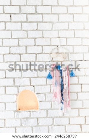 Dream catcher hanging on white brick wall (sweet dream).