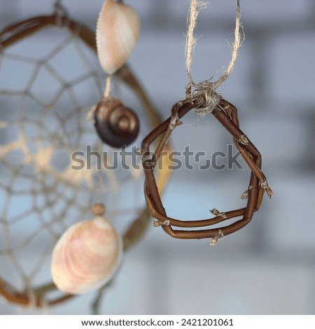 Dream catcher made of natural materials on the background of a brick wall needlework