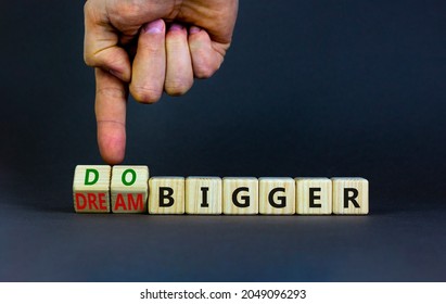 Dream And Do Bigger Symbol. Businessman Turns Wooden Cubes And Changes Words Dream Bigger To Do Bigger. Business And Dream And Do Bigger Concept. Beautiful Grey Background, Copy Space.