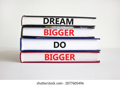 Dream And Do Bigger Symbol. Concept Words 'Dream Bigger Do Bigger' On Books On A Beautiful White Background. Businessman Hand. Business, Motivational And Dream And Do Bigger Concept.