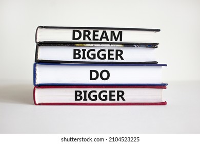 Dream And Do Bigger Symbol. Concept Words 'Dream Bigger Do Bigger' On Books On A Beautiful White Background. Businessman Hand. Business, Motivational And Dream And Do Bigger Concept.