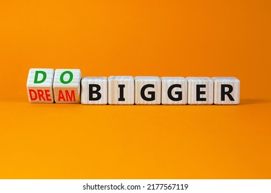 Dream And Do Bigger Symbol. Turned Wooden Cubes And Changed Words Dream Bigger To Do Bigger. Business And Dream And Do Bigger Concept. Beautiful Orange Background, Copy Space.