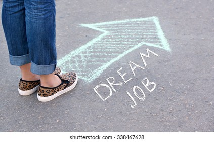 Dream Job Concept. Female Feet And Drawing Arrow On Pavement Background