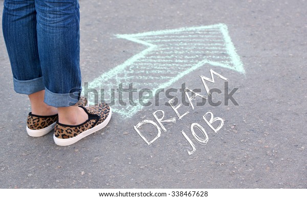 Dream job concept. Female feet and drawing\
arrow on pavement\
background