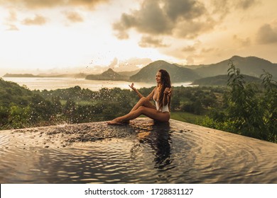 Dream Journey In Asia. Woman Sitting On Edge Luxury Infinity Pool An Enjoying Amazing Mountain, Rice Terraces And Coastline View At Sunset. Inspiration Travel Destination.