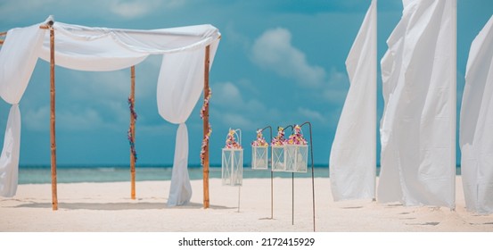 Dream Romantic Beach Wedding Decoration, White Sand And Blue Cloudy Sky. Couple Love Honeymoon And Anniversary Celebration, Sunny Soft Pastel Colored Setting, Flowers And Candles Under White Curtains