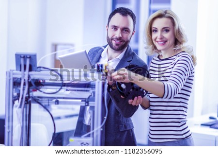 Dream team. Charming blonde woman keeping smile on her face while helping her partner with pleasure