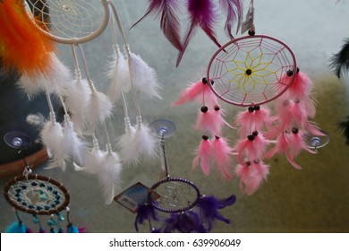 Dream Weaver Feather Designs In Various Colors Hanging In Window