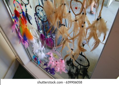 Dream Weaver Feather Designs In Various Colors Hanging In Window