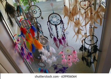 Dream Weaver Feather Designs In Various Colors Hanging In Window