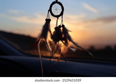 dreamcatcher, car interior, sunset, dusk, hanging dreamcatcher, boho, vehicle, rear view mirror, travel, road trip, peaceful, spiritual, bohemian style, colorful sky, twilight, silhouette, cozy, nativ - Powered by Shutterstock