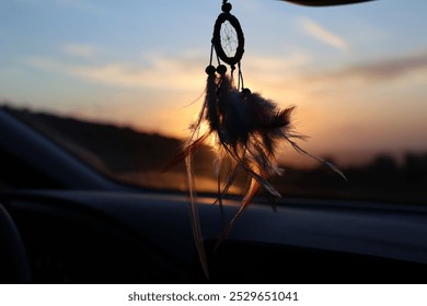 dreamcatcher, car interior, sunset, dusk, hanging dreamcatcher, boho, vehicle, rear view mirror, travel, road trip, peaceful, spiritual, bohemian style, colorful sky, twilight, silhouette, cozy, nativ - Powered by Shutterstock