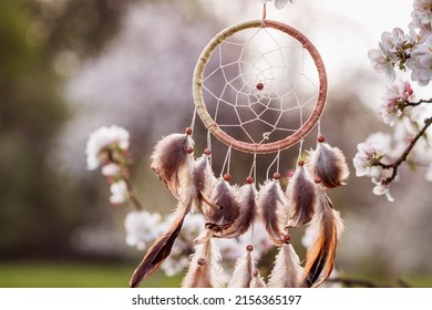 Dreamcatcher hanging on blooming tree in wind at springtime. Magical and ritual ornament for good dreaming