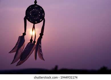 Dreamcatcher with white feather thread and beaded string. Handmade Dreamcatcher.The light of the setting sun.                        