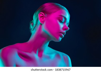 Dreamful. Portrait of female fashion model in neon light on dark studio background. Beautiful caucasian woman with trendy make-up and well-kept skin. Vivid style, beauty concept. Close up. Copyspace
