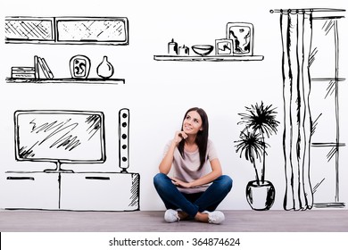 Dreaming about new apartment. Cheerful young woman smiling while sitting on the floor against white background with drawn home interior - Powered by Shutterstock