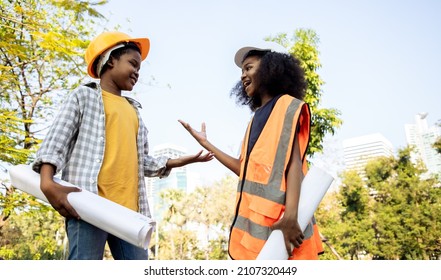 Dreaming engineering kid, Young girl and boy with the idea of ​​becoming an engineer in the future. Passing on business to heirs. Roleplay in public park middle of cityscape - Powered by Shutterstock