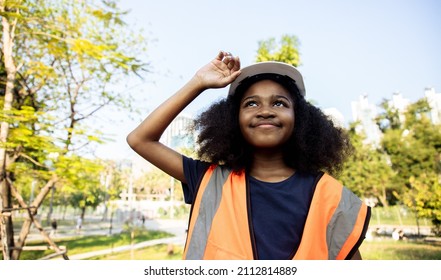 Dreaming engineering kid, Young girl with the idea of ​​becoming an engineer in the future. Passing on business to heirs. Roleplay in public park middle of cityscape - Powered by Shutterstock