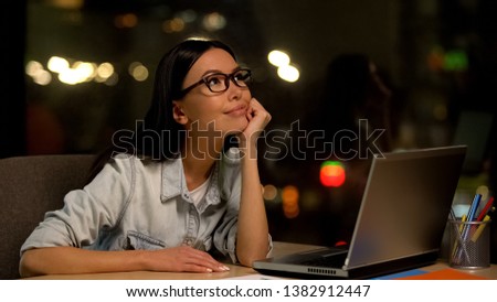 Dreaming woman sitting front laptop, tired of boring work, inattentive employee