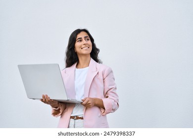 Dreaming young middle eastern Israel businesswoman using laptop pc online application for work isolated on white wall. Indian, arabic woman in business suit holding computer, looking aside. Copy space - Powered by Shutterstock