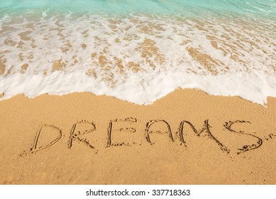 Dreams message on the beach sand - vacation and travel concept