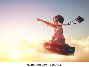 Dreams of travel! Child flying on a suitcase against the backdrop of a sunset. - Shutterstock ID 400379983