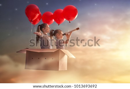 Dreams of travel! Two children are flying in cardboard box with air balloons.