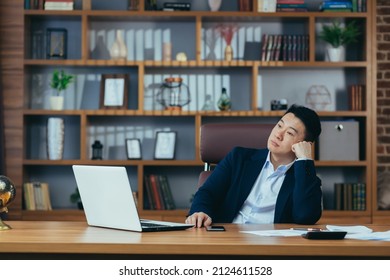 Dreamy Asian Businessman Sitting At His Desk In The Office, Boss Thinking About Future Investment Projects