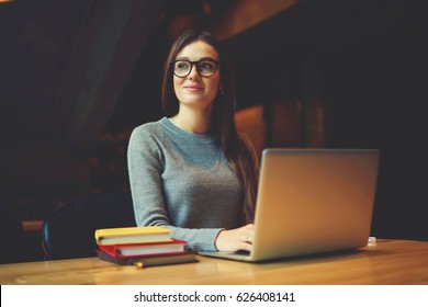 Dreamy Attractive Female Student Thinking About Coursework Strategy Sitting In University Library With Laptop Computer Connected To Wireless Internet,talented Editor Of Online Issue Creating Article 
