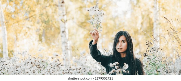 Dreamy beautiful girl in thistle thickets on bokeh background of yellow leaves. Inspired girl with white thistle flowers bouquet in autumn forest. Female beauty portrait among flying spores of thistle - Shutterstock ID 2279502721