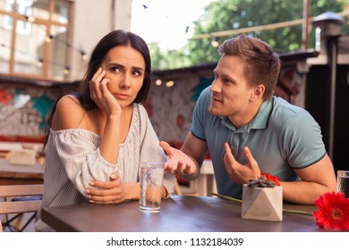 Dreamy And Concerned. Appealing Stylish Woman Feeling Dreamy And Concerned While Sitting Near Her Boyfriend